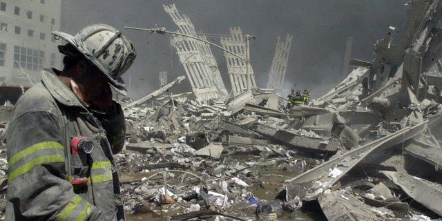 A firefighter walks through the rubble of the World Trade Center after it was struck by a commercial airliner in a terrorist attack.