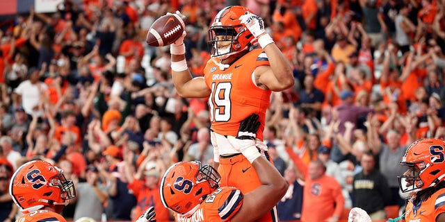 Matthew Bergeron #60 lifts Oronde Gadsden II #19 of the Syracuse Orange after Gadsden II scored a touchdown during the fourth quarter against the Purdue Boilermakers at JMA Wireless Dome on September 17, 2022 in Syracuse, New York. 