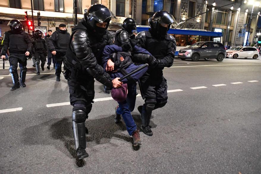 Riot police arrest a man in St. Petersburg on Wednesday.