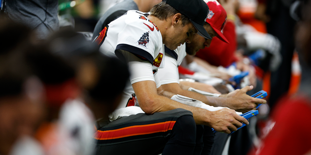 Tom Brady of the Tampa Bay Buccaneers looks at a tablet during the game against the New Orleans Saints at Caesars Superdome in New Orleans on Sept. 18, 2022.