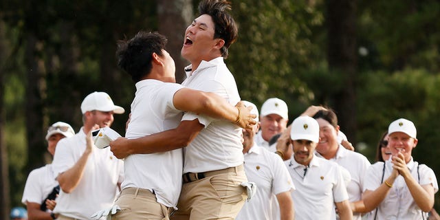 Tom Kim of South Korea and Si Woo Kim of South Korea and the International Team celebrate Tom Kim's hole-winning putt on Sept. 24, 2022 in Charlotte, North Carolina.