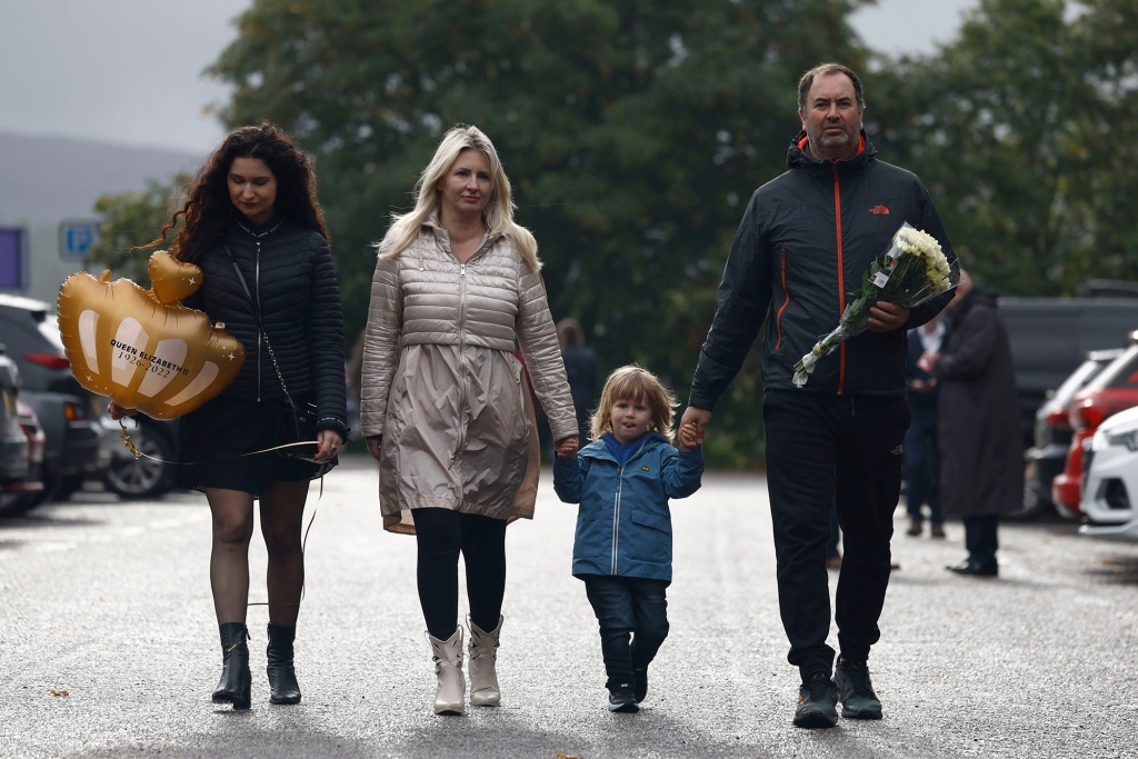 A family arrives to lay flowers by the gates of Balmoral Castle.