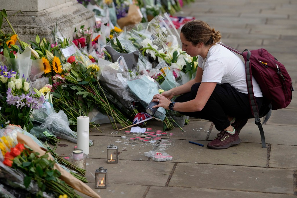 A mourner lights a candle outside Buckingham Palace in London on Sept. 9, 2022. 