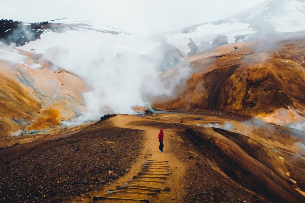 Exterior of a hiker at the panoramic geothermal smoking bright colorful mountain land in Iceland Highlands.