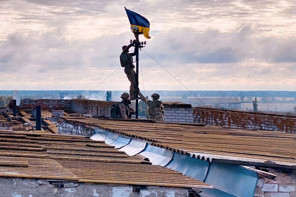 A photo of a soldier raising the Ukrainian flag over the village of Vysokopillya in the Kherson region. 
