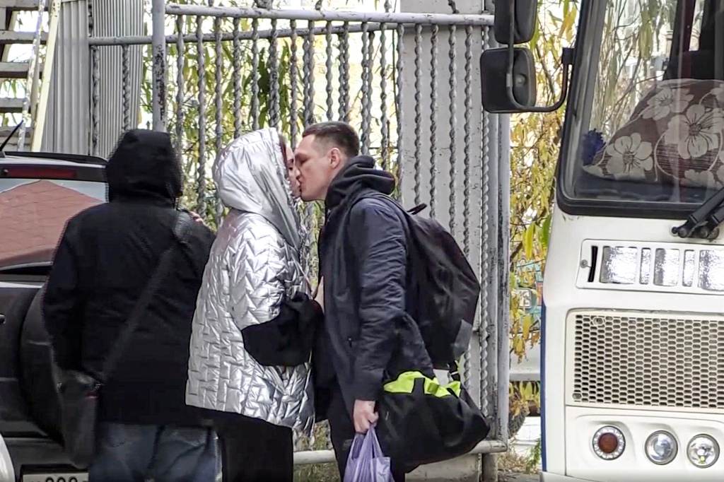 In this image taken from video, a Russian draftee kisses his partner before boarding a bus to be sent to the military units of the Eastern Military District, in Yakutsk, Russia, Friday.