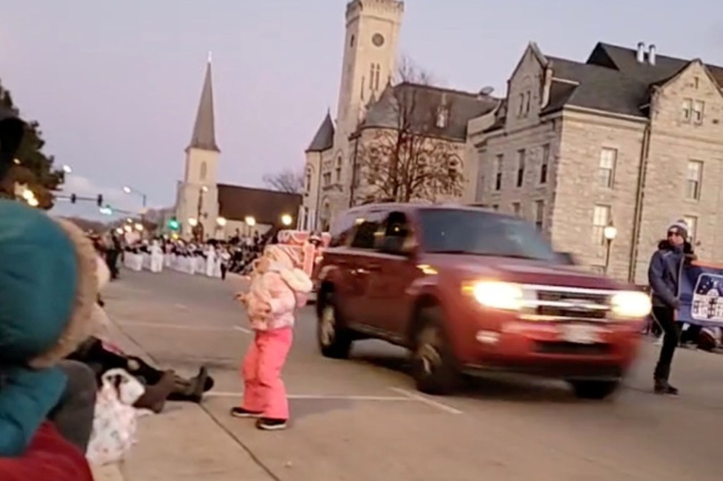 An SUV speeds past moments before plowing into a crowd of people during a Waukesha Christmas parade