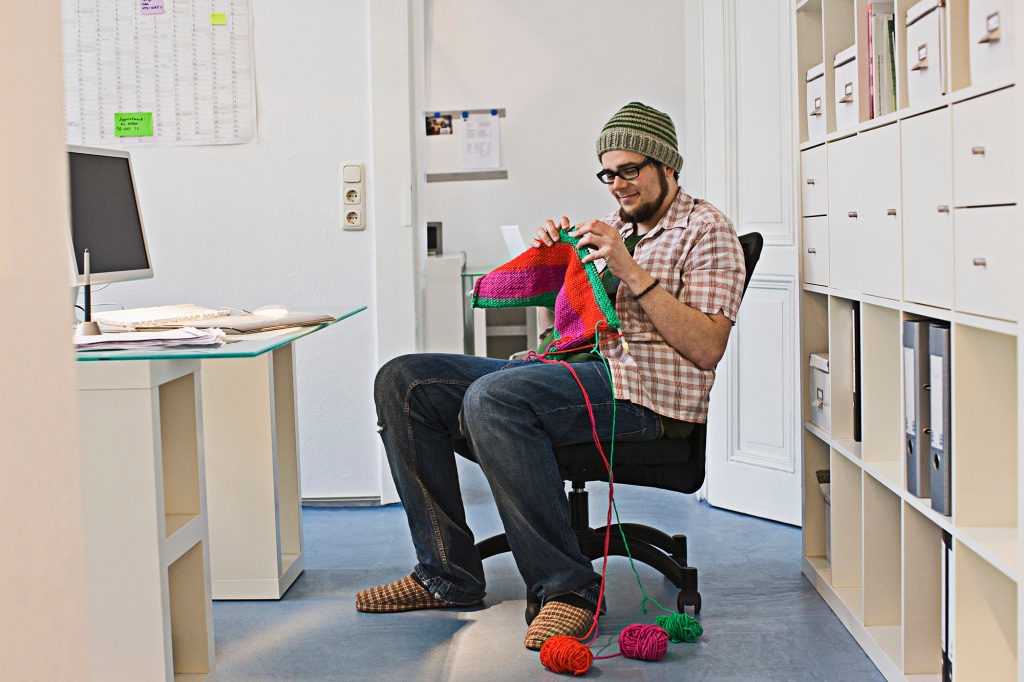 Man knitting at a desk