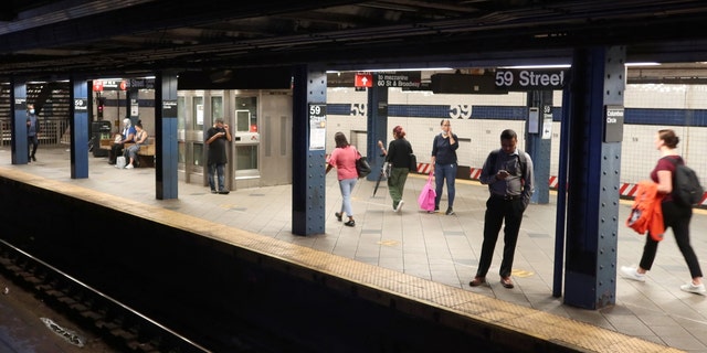 People wait for a subway train to arrive at the Columbus Circle - 59th Street station on Aug. 11, 2022, in New York City. 