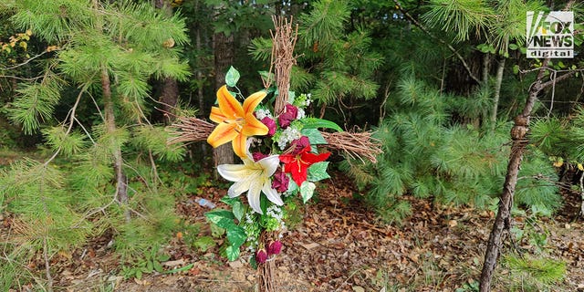 The entrance to the crime scene where Debbie Collier was found dead on September 11, 2022, is marked with a makeshift memorial in the shape of a cross. 