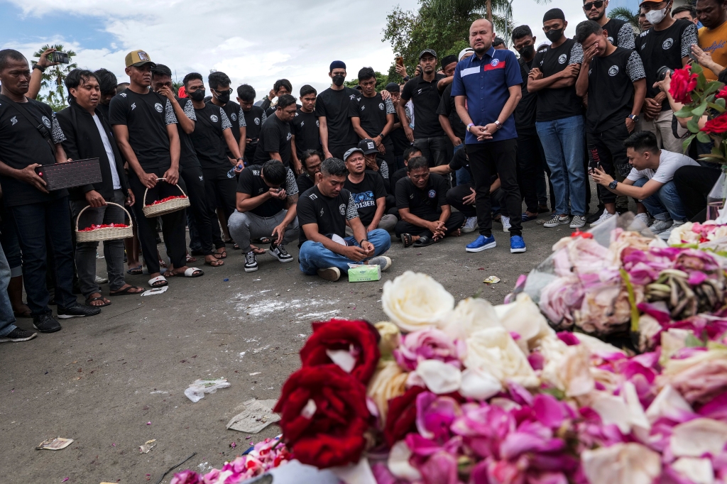 Players and officials of Arema FC mourn as they pay condolence to the victims outside Kanjuruhan Stadium on Oct. 3, 2022 in Malang, Indonesia.