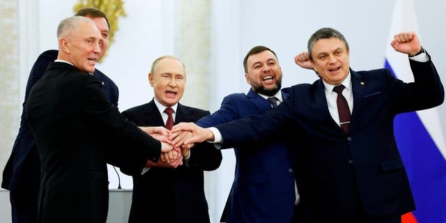 From left, Moscow-appointed head of Kherson Region Vladimir Saldo; Moscow-appointed head of Zaporizhzhia region Yevgeny Balitsky; Russian President Vladimir Putin; Denis Pushilin, leader of self-proclaimed Donetsk People's Republic; and Leonid Pasechnik, leader of self-proclaimed Luhansk People's Republic, pose for a photo during a ceremony to sign the treaties for four regions of Ukraine to join Russia at the Kremlin in Moscow on Friday.