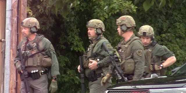 Police prepare to enter the hotel where a man was found shot to death in Poughkeepsie, NY, Sunday October 2, 2022.