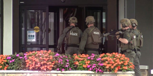 Police enter the hotel where a man was found shot to death in Poughkeepsie, New York, Sunday Oct. 2, 2022.