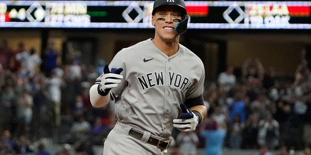 New York Yankees' Aaron Judge gestures as he rounds the bases after hitting a solo home run, his 62nd of the season, during the first inning in the second baseball game of a doubleheader against the Texas Rangers in Arlington, Texas, Tuesday, Oct. 4, 2022. With the home run, Judge set the AL record for home runs in a season, passing Roger Maris.