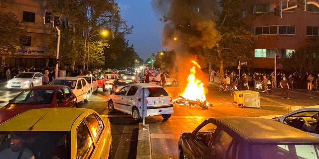 A police motorcycle burns during a Sept. 19, 2022, protest in Tehran, Iran, over the death of Mahsa Amini, a young Iranian woman who died after being arrested by the nation's "morality police." (West Asia News Agency via Reuters)