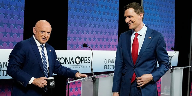 Arizona Democratic Sen. Mark Kelly, left, and his Republican challenger Blake Masters arrive onstage prior to a televised debate in Phoenix Oct. 6, 2022. 