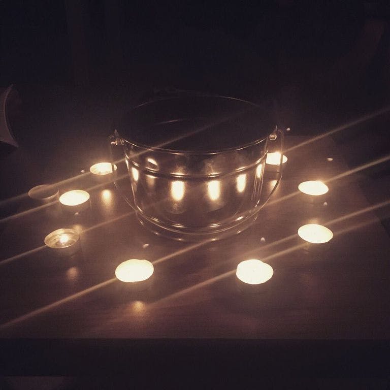 ten candles around a copper pot