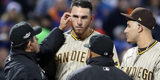 Umpire Alfonso Marquez, left, checks for illegal substances on San Diego Padres pitcher Joe Musgrove during Game 3 of the wild-card series at Citi Field in New York on Oct. 9, 2022.