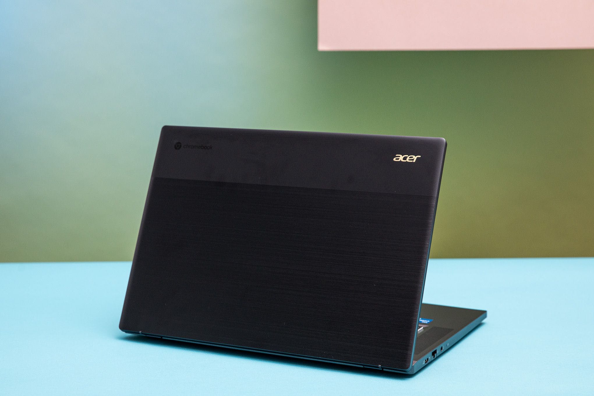 The Acer Chromebook 516 GE faced away from the camera, showing off its two-toned display lid. Most of it is a brushed texture, while a sliver of it appears anodized with a soft touch.