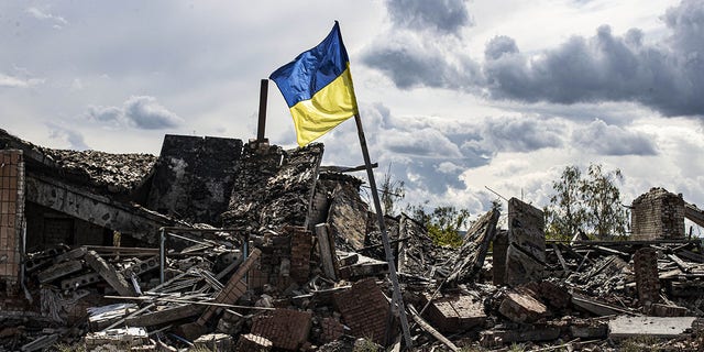 A Ukrainian flag waves in a residential area of the heavily damaged village of Dolyna in Donetsk Oblast, Ukraine after the withdrawal of Russian troops on Sept. 24.