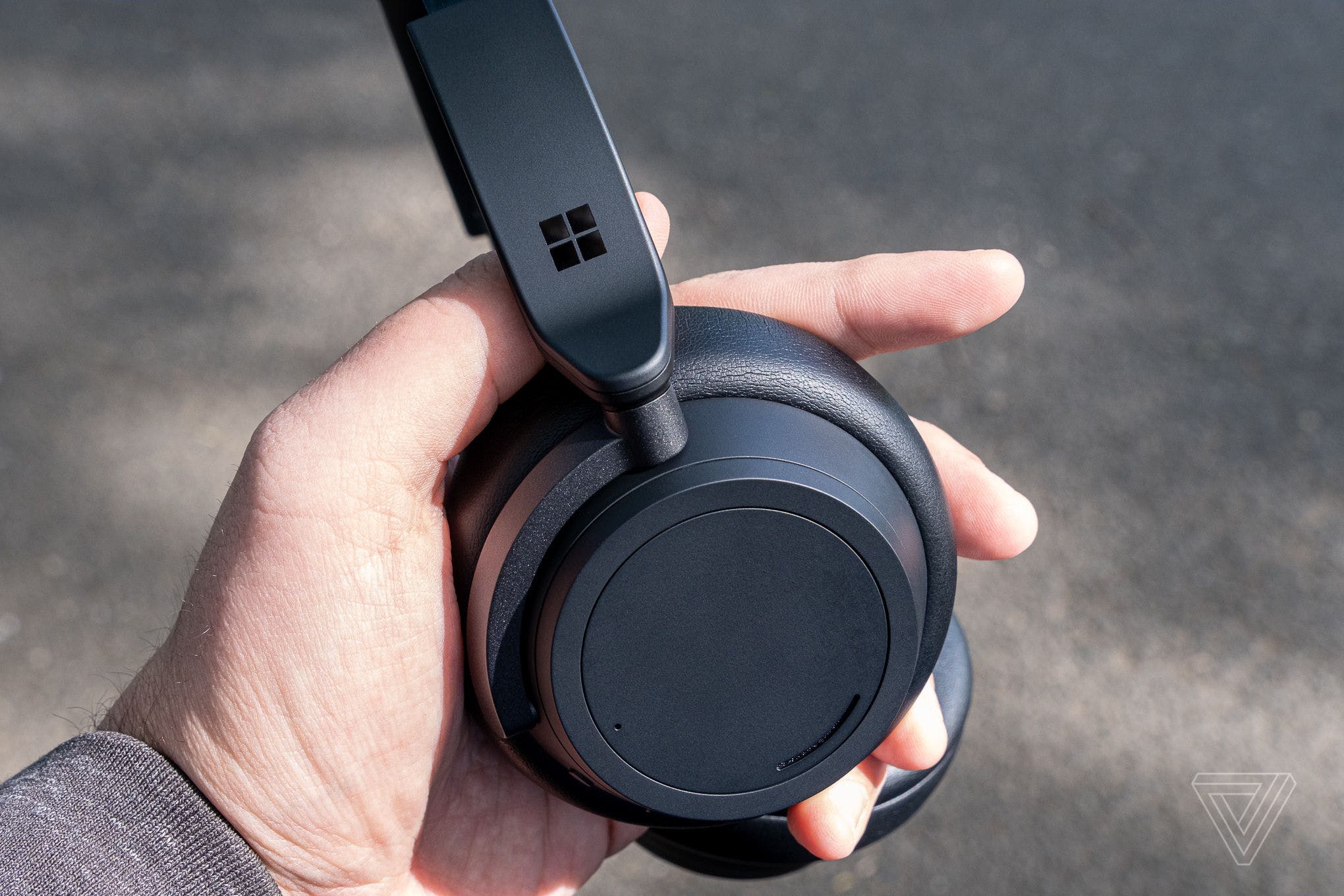 The matte black Surface Headphones 2 pictured in the reviewer’s hand.