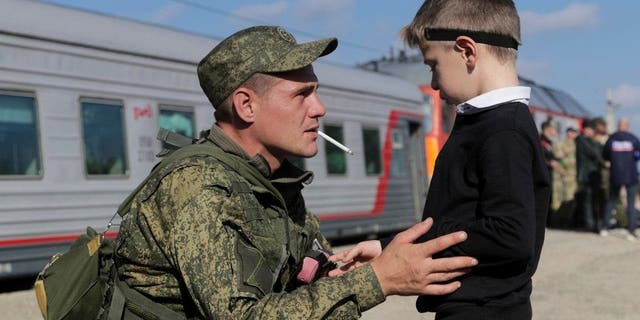 A Russian recruit speaks to his son at a railway station in Prudboi, Volgograd region of Russia, on Sept. 29, 2022.