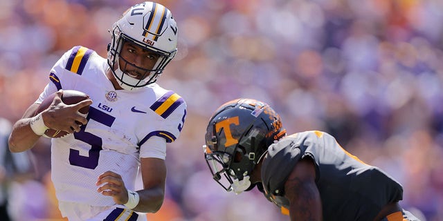 Jayden Daniels #5 of the LSU Tigers runs with the ball as Jaylen McCollough, #2, of the Tennessee Volunteers defends during the first half of a game at Tiger Stadium on October 8, 2022, in Baton Rouge, Louisiana. 