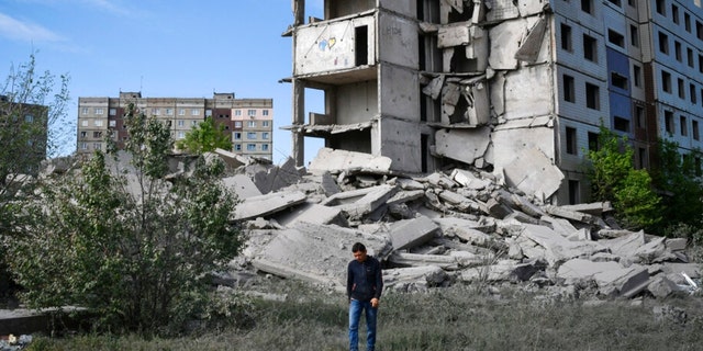 A local resident walks next to an apartment building destroyed in a Russian shelling in Kramatorsk, Ukraine. Two American were reportedly killed in the country. 