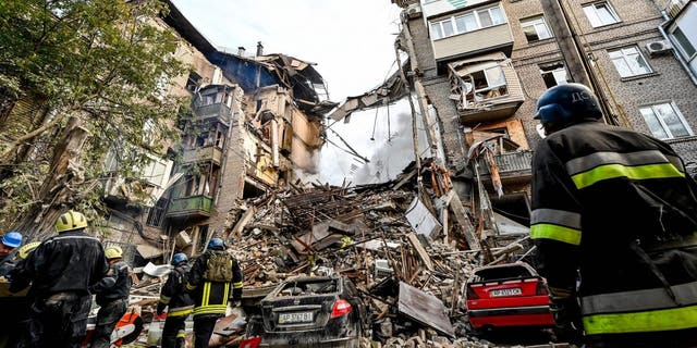 Ukrainian firefighters push out a fire after a strike in Zaporizhzhia on Oct. 6, 2022, amid the Russian invasion of Ukraine.