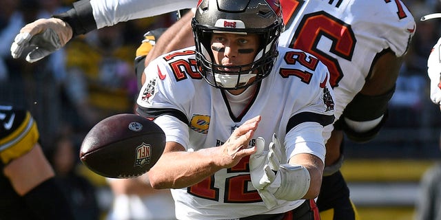 Tampa Bay Buccaneers quarterback Tom Brady (12) laterals to running back Leonard Fournette during the second half of an NFL football game against the Pittsburgh Steelers in Pittsburgh, Sunday, Oct. 16, 2022. 