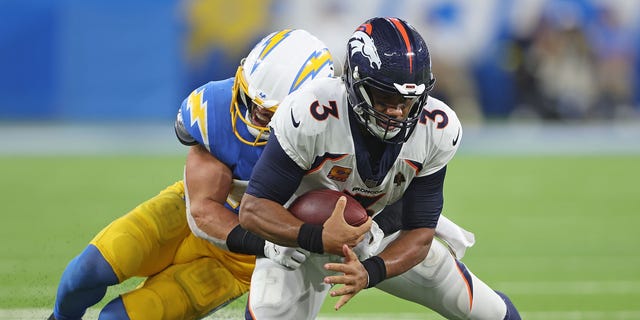 Russell Wilson, #3 of the Denver Broncos, is sacked by Drue Tranquill, #49 of the Los Angeles Chargers, during the fourth quarter at SoFi Stadium on Oct. 17, 2022 in Inglewood, California.