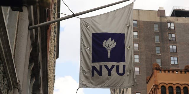 New York University (NYU) flag flies outside a Covid-19 test tent outside of the NYU business school on August 25, 2020 in New York City.