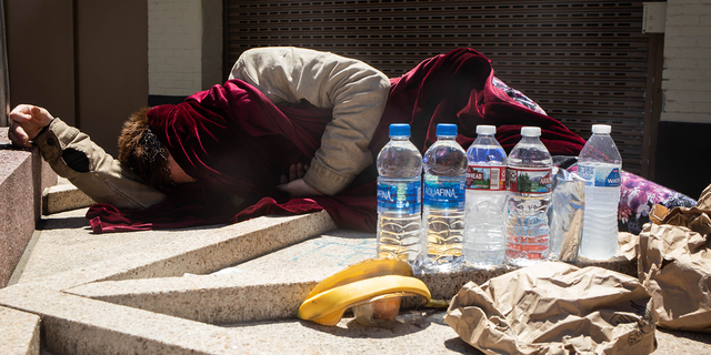 A homeless person sleeps in the sun during a heatwave in Portland, Oregon, U.S., on Monday, June 28, 2021.