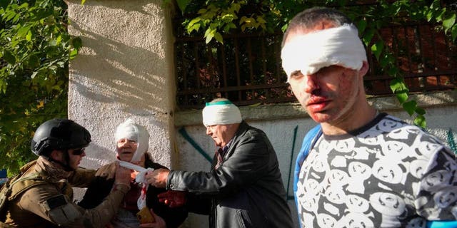 People receive medical treatment at the scene of Russian shelling, in Kyiv, Ukraine, Oct. 10, 2022. Multiple explosions rocked Kyiv early Monday following months of relative calm in the Ukrainian capital. Kyiv Mayor Vitali Klitschko reported explosions in the city's Shevchenko district, a large area in the center of Kyiv that includes the historic old town as well as several government offices. (AP Photo/Efrem Lukatsky, File)