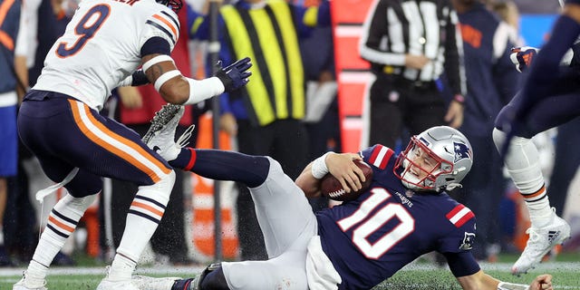 Mac Jones #10 of the New England Patriots slides down after running with the ball during the first half against the Chicago Bears at Gillette Stadium on October 24, 2022 in Foxborough, Massachusetts.