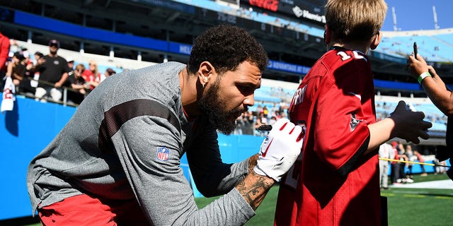 Mike Evans of the Tampa Bay Buccaneers signs a young fan's jersey prior to a game against the Carolina Panthers at Bank of America Stadium Oct. 23, 2022, in Charlotte, N.C. 