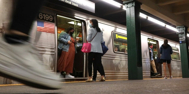 People wait to board a subway train at the West 4th Street station on October 9, 2022, in New York City. 