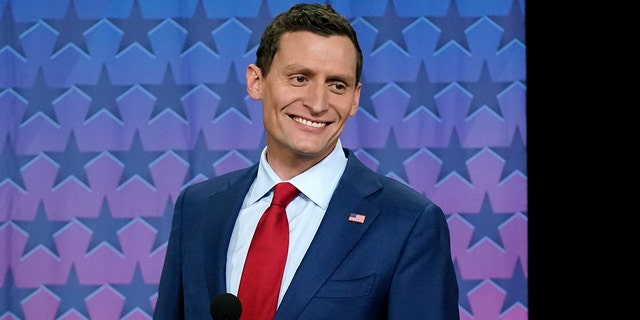 Republican Arizona Senate nominee Blake Masters smiles on stage prior to a televised debate with Arizona Democratic Sen. Mark Kelly and Libertarian candidate Marc Victor.