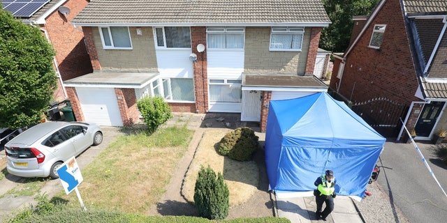 A police officer stands outside Lucy Letby's house in Chester, England, on July 4, 2018.