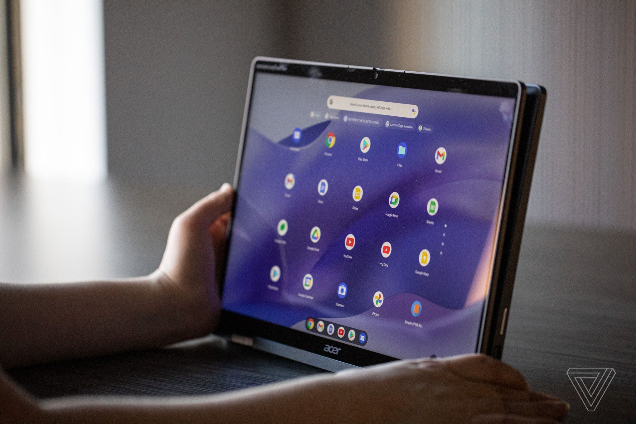 A user holds the Acer Chromebook Spin 714 in tablet mode. The screen displays Launcher on a purple background.