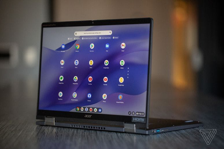 The Acer Chromebook Spin 714 open on a conference room table. The screen displays the ChromeOS Launcher.