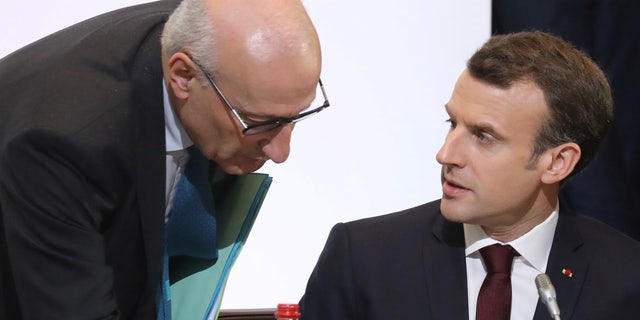 French President Emmanuel Macron, right, speaks with presidential diplomatic advisor Philippe Etienne during the Cedar Conference for international donors and investors to support Lebanon's economy, in Paris April 6, 2018.   