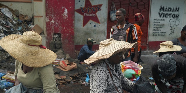 Women offer produce at a market while people stock up on food amid shortages of water, cooking gas and other items after days of protest forced them to shelter at home, in Port-au-Prince, Haiti Sept. 17, 2022.  