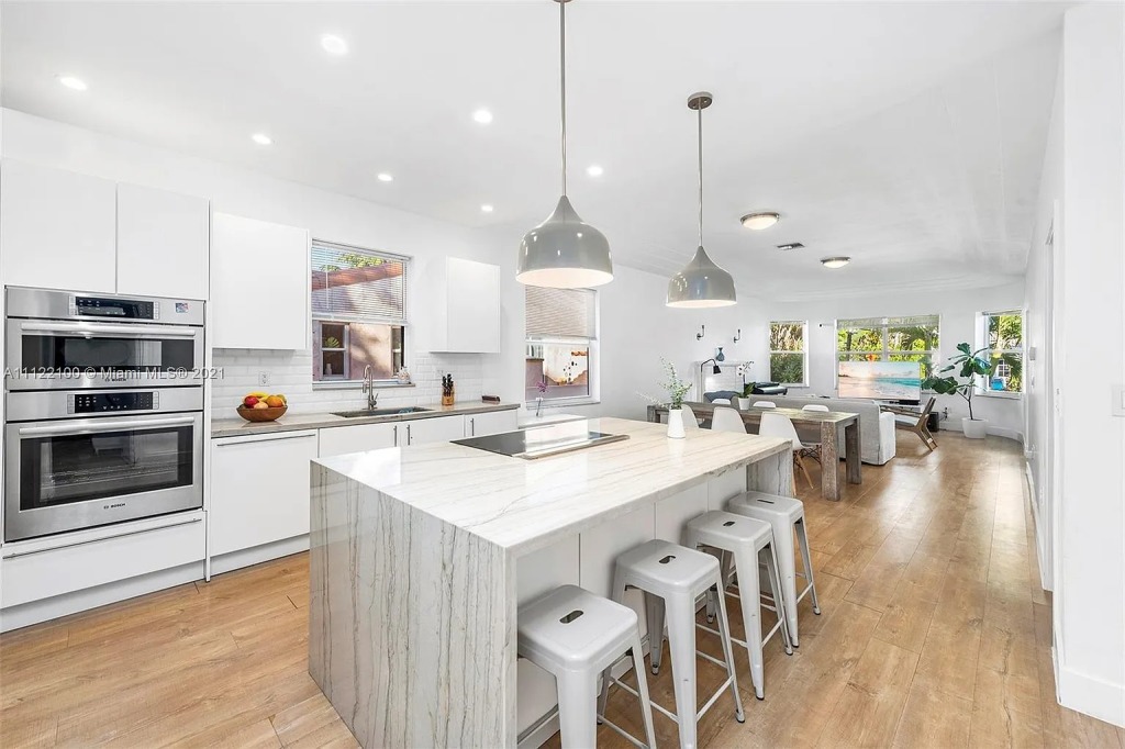 A view of the open floor plan which includes a marble island kitchen.