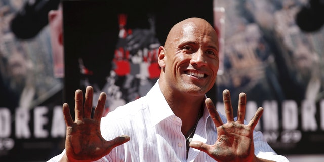 Actor Dwayne "The Rock" Johnson poses after putting his hands in cement during his hand and footprints ceremony in the forecourt of the TCL Chinese Theatre in celebration of his movie "San Andreas," in Hollywood, California May 19, 2015.