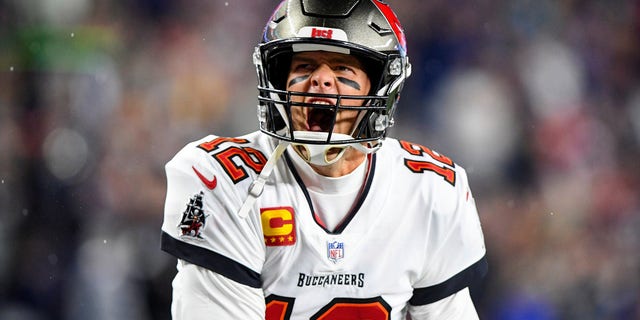 Tampa Bay Buccaneers quarterback Tom Brady yells to the crowd as he takes the field to face the New England Patriots at Gillette Stadium.  