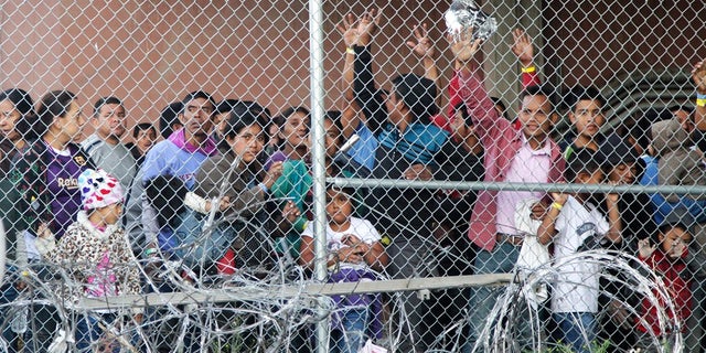 Central American migrants wait for food in El Paso, Texas, in a pen erected by U.S. Customs and Border Protection to process a surge of migrant families and unaccompanied minors on March 27, 2019.