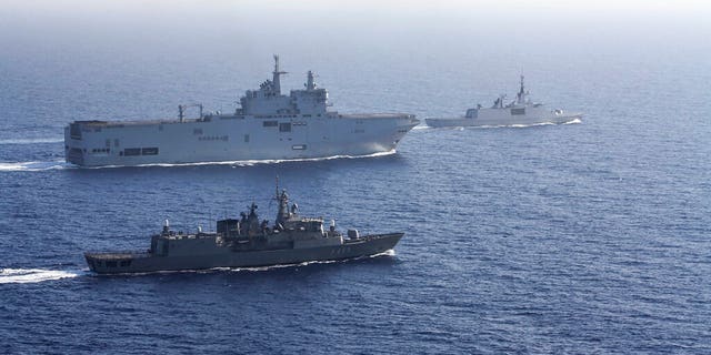 In this photo provided by the Greek National Defence, a French Tonnerre helicopter carrier, rear left is escorted by Greek and French military vessels during a maritime exercise in the Eastern Mediterranean, Thursday, Aug. 13, 2020. Greece's prime minister warmly thanked France for its decision to boost its military presence in the eastern Mediterranean, where Greek and Turkish warships are closely shadowing each other over a Turkish energy exploration bid in waters Athens claims as its own. 