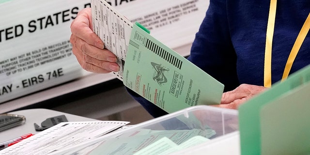 Election workers sort ballots Wednesday, Oct. 21, 2020, at the Maricopa County Recorder's Office in Phoenix.